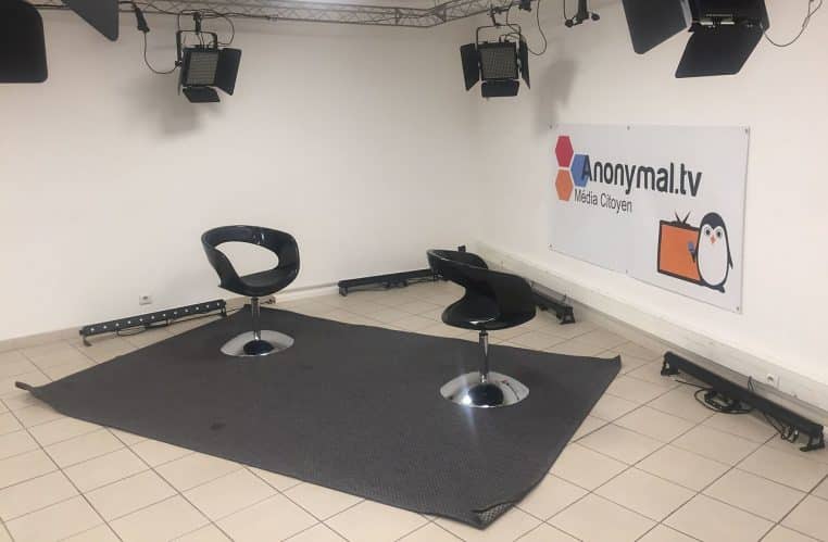 Plateau télévisé vide avec canapés et projecteurs.