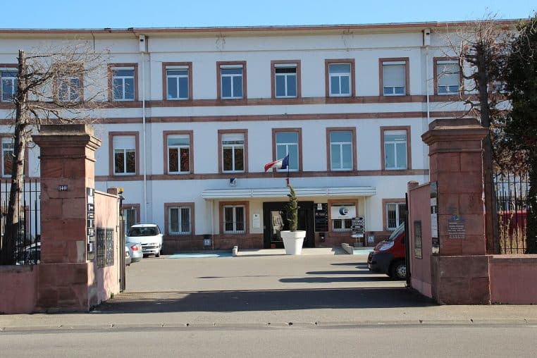 Entrée d’une agence de l’ex-Pôle emploi à Colmar, bâtiment vitré avec logo visible.