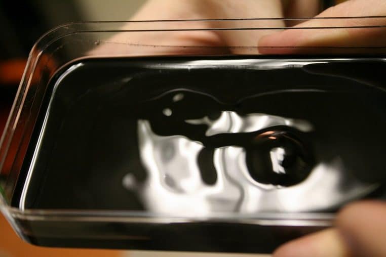 Expérience avec ferrofluide montrant les pics formés autour d’un aimant puissant, vue rapprochée.