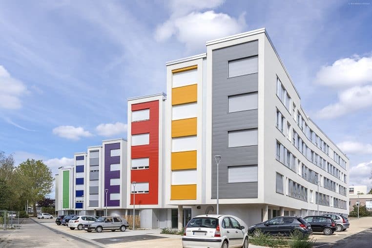 Façades orange et grises d’une résidence étudiante moderne.