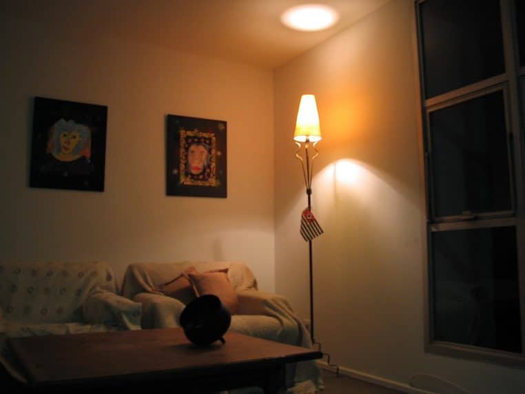 Salon chaleureux avec canapé, table basse et lampe à incandescence allumée.