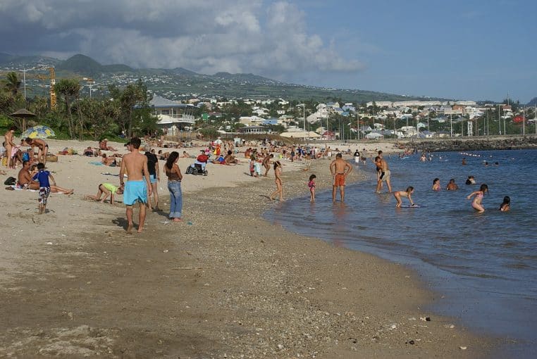 Large plage de Saint-Pierre à la Réunion, eau turquoise, barrière de corail visible sous une lumière franche.