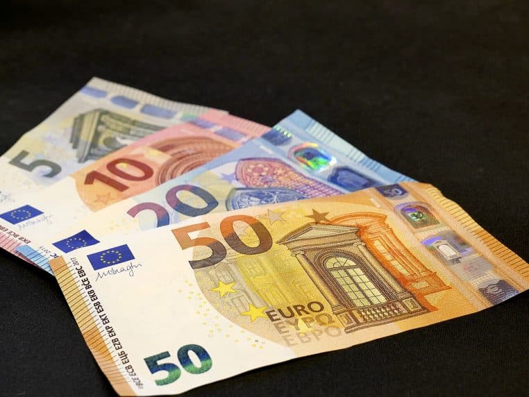 Quatre billets en euros de la série Europa (5, 10, 20, 50) alignés sur une surface claire, pour illustrer les repères de revenus par foyer.