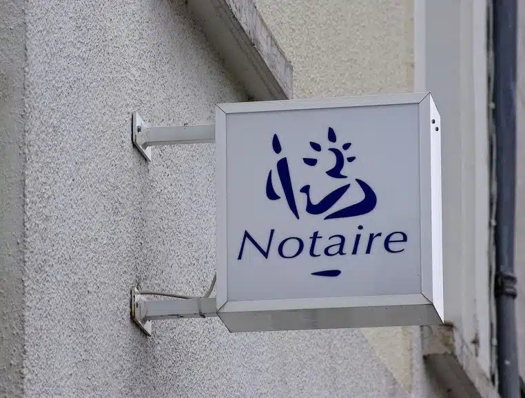 Enseigne lumineuse de notaire à Soyaux, prise en plan large, met en scène le symbole officiel des études notariales françaises.