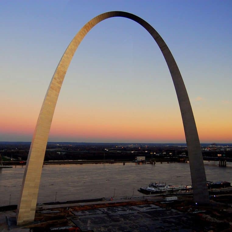 Rayonnages d’un entrepôt de banque alimentaire avec palettes filmées prêtes à être expédiées, vue en perspective.