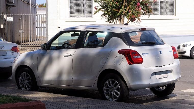 Suzuki Swift 2024 sportive blanche photographiée en extérieur.