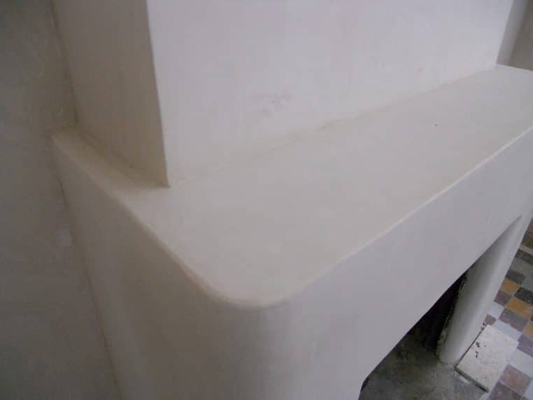 Cheminée ancienne recouverte de tadelakt, surface texturée et satinée qui capte la lumière, ambiance cocon et authentique