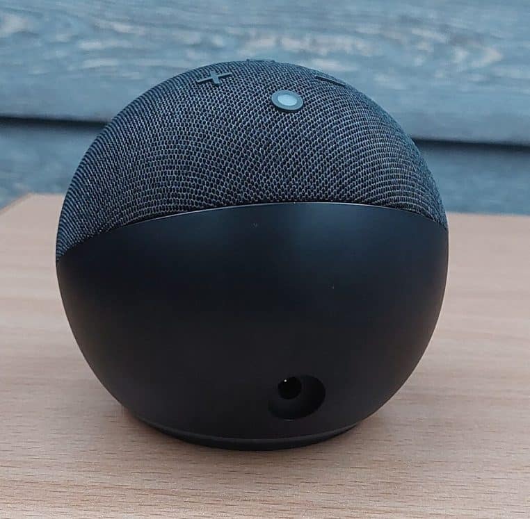 Echo Dot noir 5e génération sur table en bois.