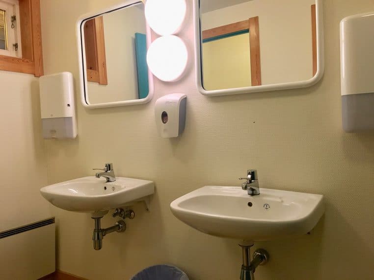 Toilettes d’école lumineuses : cuvette et lavabos brillants, miroirs propres, ambiance dépourvue d’auréoles.