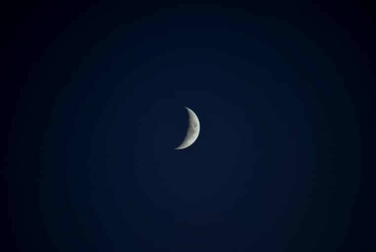 Croissant de lune détaillé sur ciel sombre, évoquant la précision d’une intention bien posée.