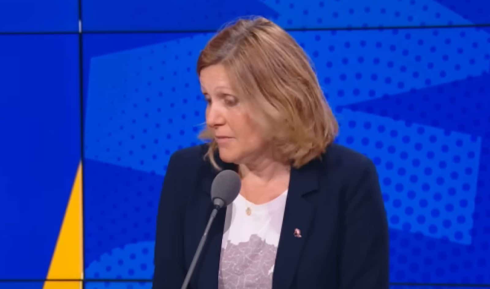 Présidente de l’Assemblée interviewée sur un plateau télé français, décor lumineux, ton sobre, caméras et pupitre visibles.