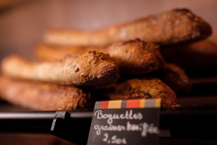 Rayon de supermarché avec des baguettes alignées en présentoir.