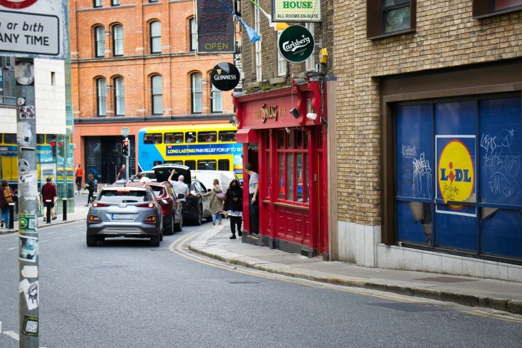 Street scene with red building and yellow bus