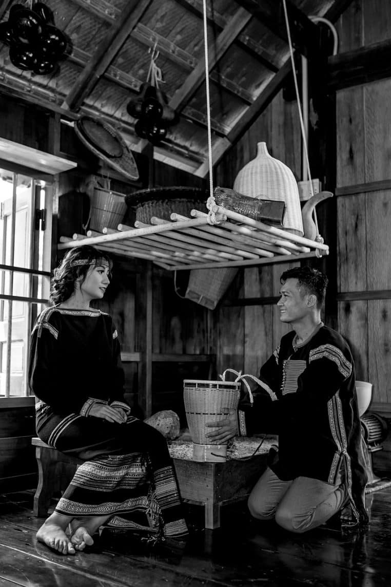 Couple assis dans un salon chaleureux au mobilier en bois, lumière douce et échange calme en fin de journée d’automne.
