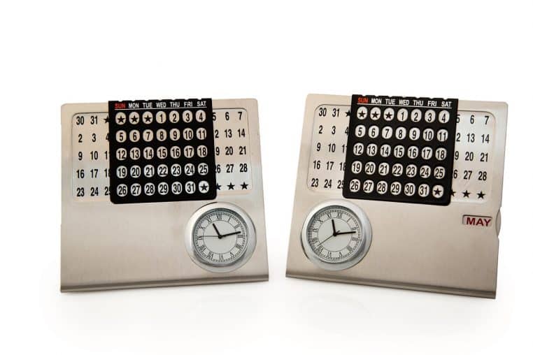: Deux petits calendriers de bureau métalliques avec horloges intégrées, illustrant une planification fine des jours de congés.