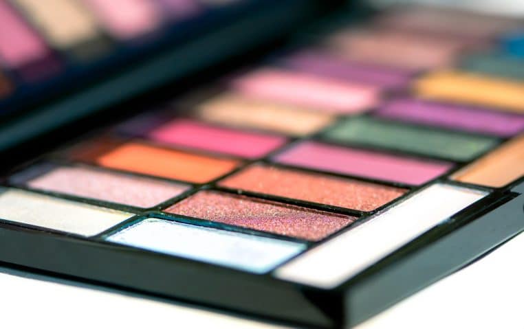 Gros plan d’une palette d’ombres à paupières et de pinceaux, idéale pour imaginer des looks de fête et créer les plus beaux maquillages.