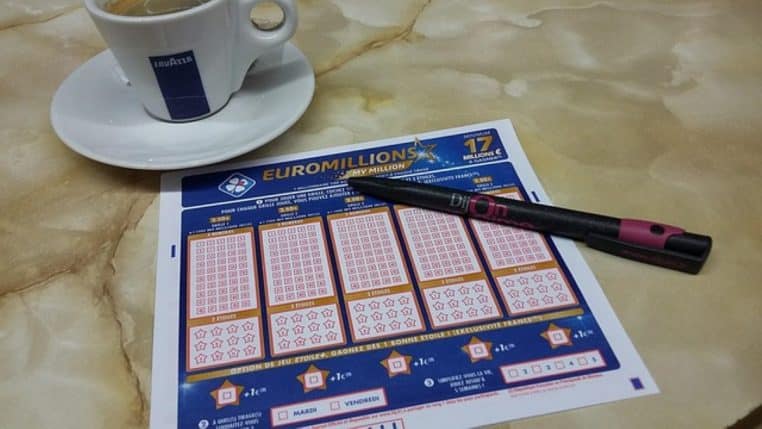 Ticket Euromillions, stylo et tasse de café sur un comptoir
