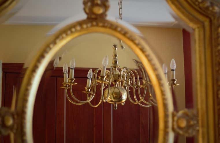 Intérieur élégant avec miroir et lampe murale, reflet chaud et composition décorative pour salon contemporain