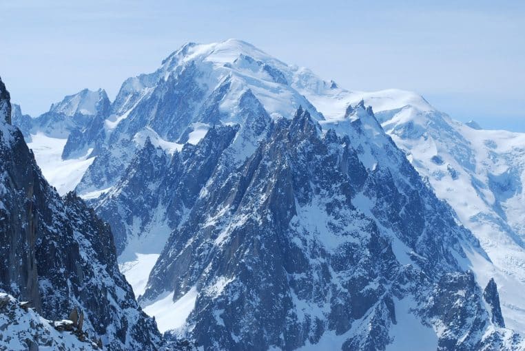 Place centrale de Chamonix, passants emmitouflés et façades colorées sous un ciel hivernal.