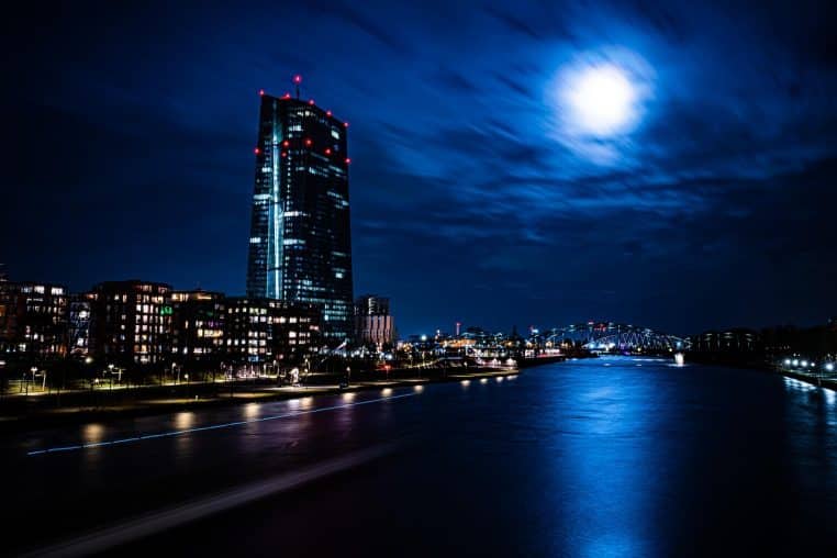 Lune brillante au-dessus d’immeubles éclairés, ciel bleu nuit