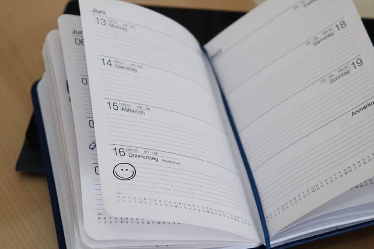 Agenda papier ouvert sur la semaine, symbole d’un fractionnement de congés réparti et anticipé dès l’automne.