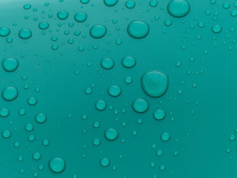 Gouttes de pluie nettes sur bâches et terre battue à Roland-Garros, matchs interrompus sous une averse à Paris.