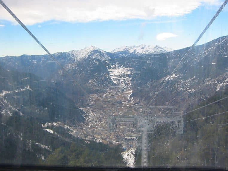 Vue plongeante vers la vallée d’Encamp et Grandvalira en Andorre, montagnes partiellement enneigées vues depuis une cabine de téléphérique.