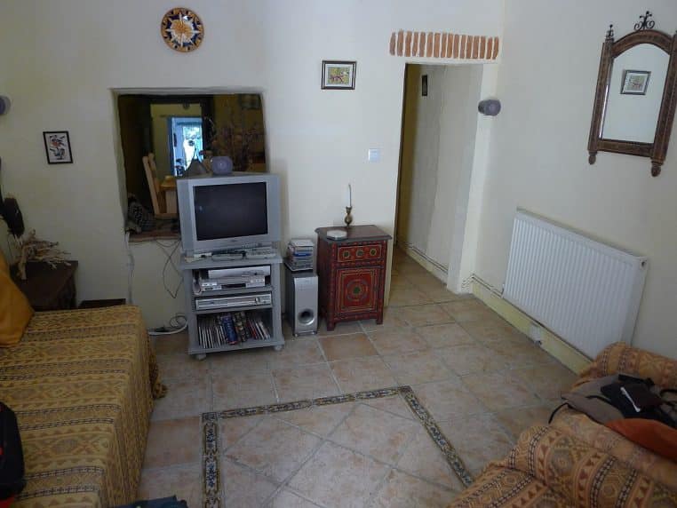 Radiateur discret sous une fenêtre dans un salon lumineux ; exemple d’émetteur bien placé pour répartir la chaleur.