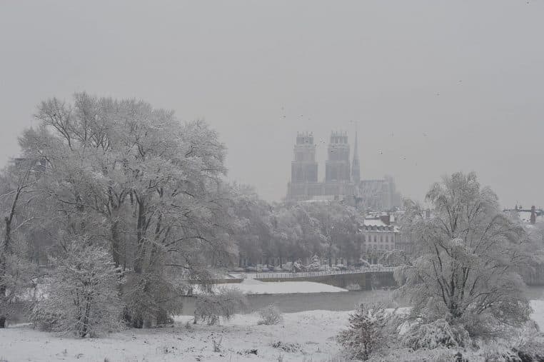 Rives de Loire à Orléans couvertes de neige en novembre 2010, berges blanches et eau sombre sous une lumière froide.