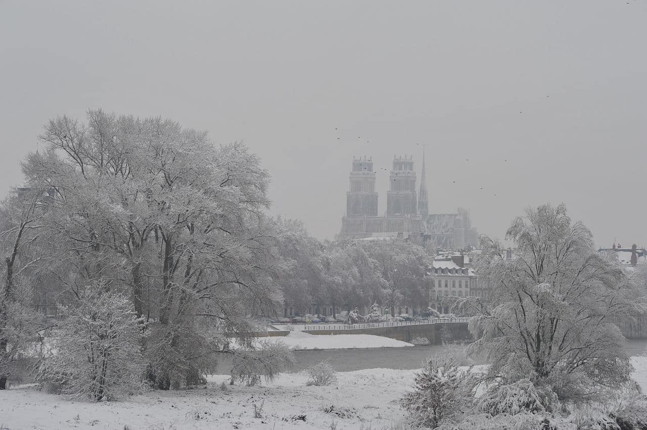 Rives de Loire à Orléans couvertes de neige en novembre 2010, berges blanches et eau sombre sous une lumière froide.