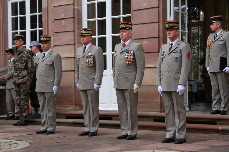 Plusieurs généraux français en uniforme clair décoré se tiennent alignés lors d’une prise d’armes officielle à Strasbourg.