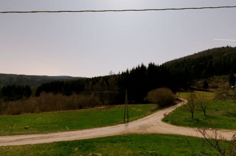 Paysage vallonné des Vosges photographié de nuit, ciel sombre étoilé et collines légèrement éclairées par un discret clair de lune.