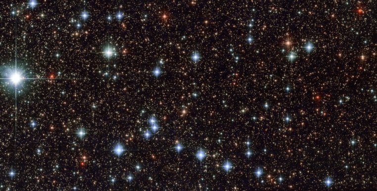 Champ d’étoiles en Sagittaire saisi par Hubble, contrastes bleus et rouges et pointes de diffraction sur les astres les plus brillants.