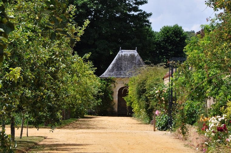 Vue rapprochée d’un abri de jardin en bois, posé sur une dalle, avec porte vitrée et végétation alentour, typique des installations à déclarer.
