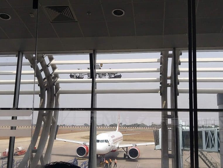 Avion de la compagnie Air India stationné au parking d’un aéroport indien, vu depuis le terminal côté piste