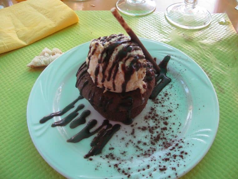 Moelleux au chocolat servi à l’assiette avec glace, contraste chaud-froid et cœur fondant souligné par la lumière du restaurant.