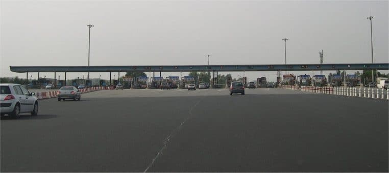 Barrière de péage sur autoroute en France avec plusieurs voies et panneaux, photographie horizontale de jour
