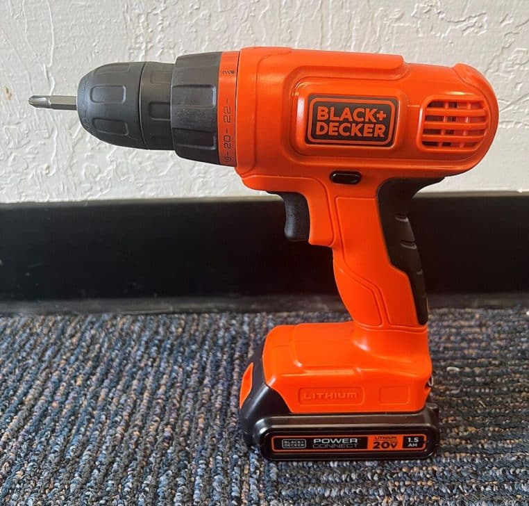 Perceuse sans fil Black & Decker posée de profil sur surface plane, gros plan en format horizontal.