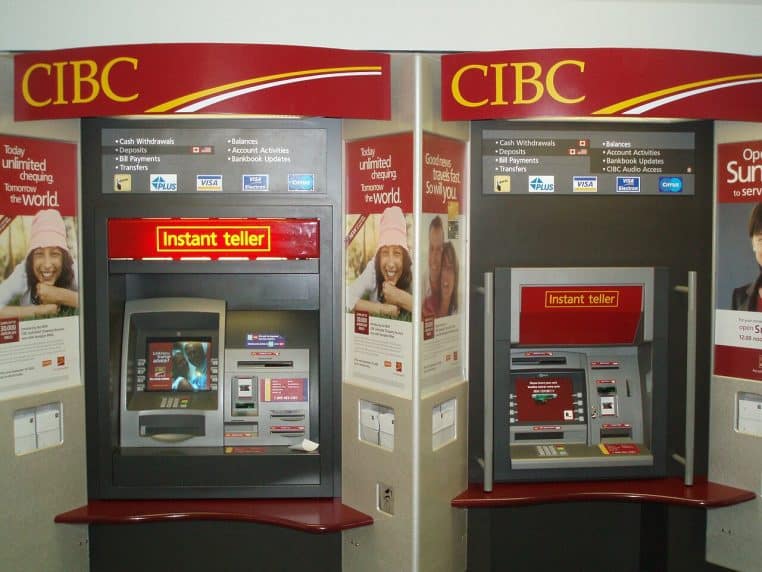 Intérieur de centre commercial avec distributeur automatique de billets en fonctionnement, vue horizontale large, panneau CIBC visible et éclairage homogène.