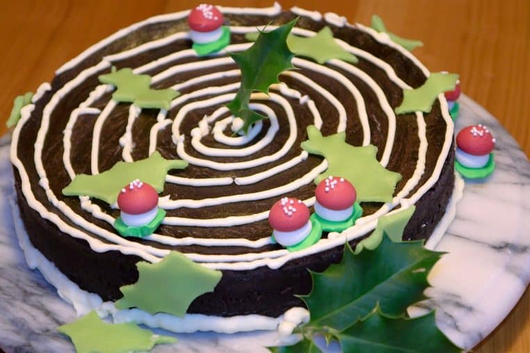 Cake moelleux au chocolat décoré, format familial, découpe nette laissant deviner une mie dense et brillante sous lumière naturelle.