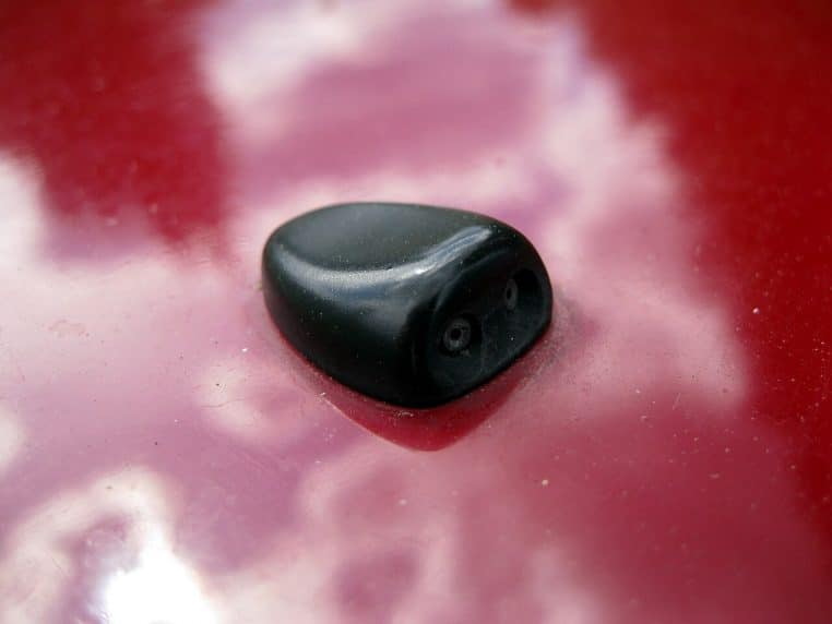 Gros plan sur un pare-brise de voiture avec gicleur de lave-glace, prêt à recevoir une vignette sur le coin droit de la vitre.