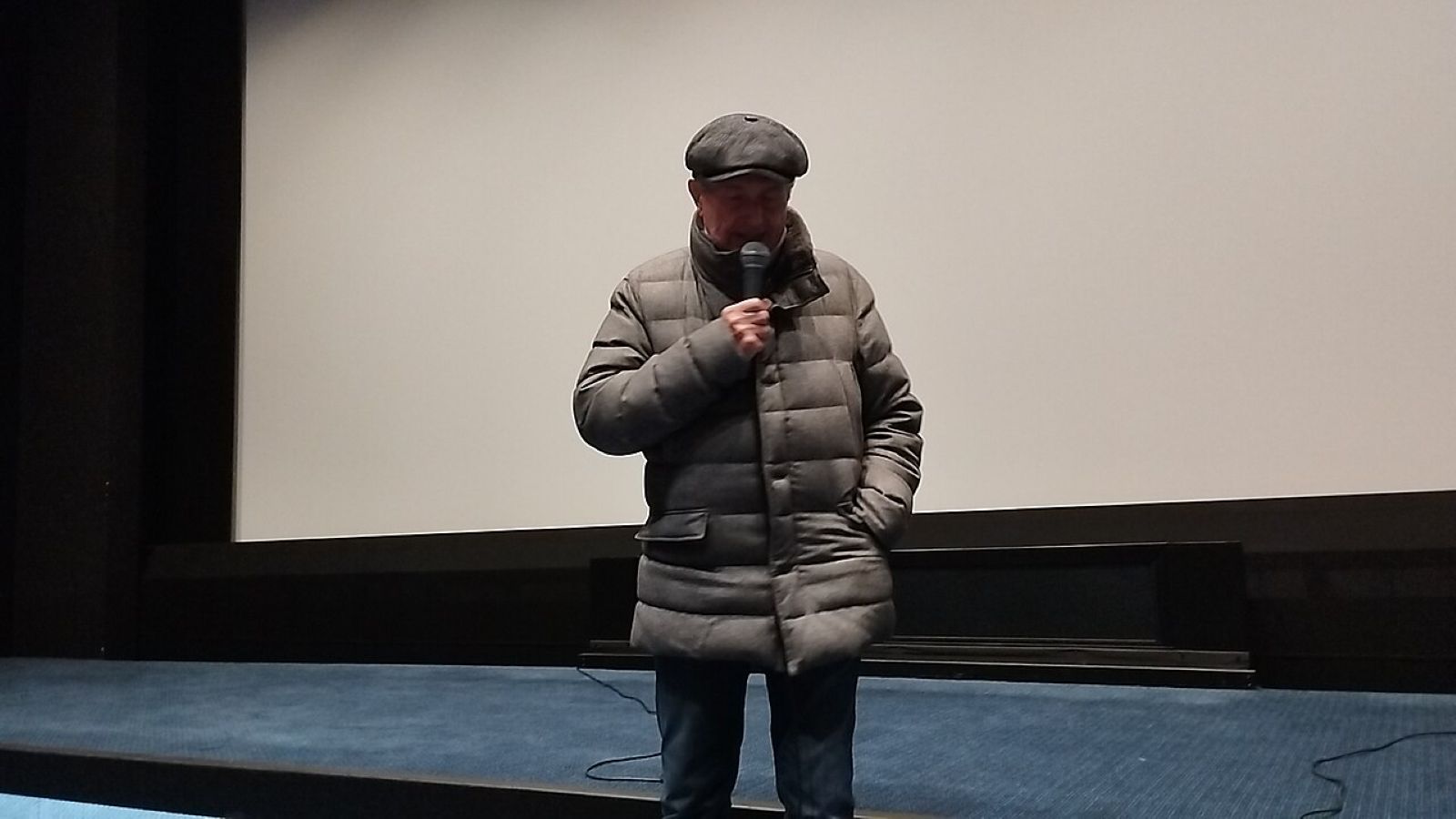 Claude Lelouch souriant à la Cinémathèque française, plan poitrine, novembre 2024, éclairage d’intérieur en soirée.