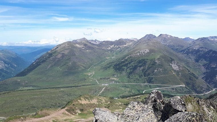 Large panorama du col de Puymorens vu de l’Estanyol, crêtes enneigées et vallons éclairés.
