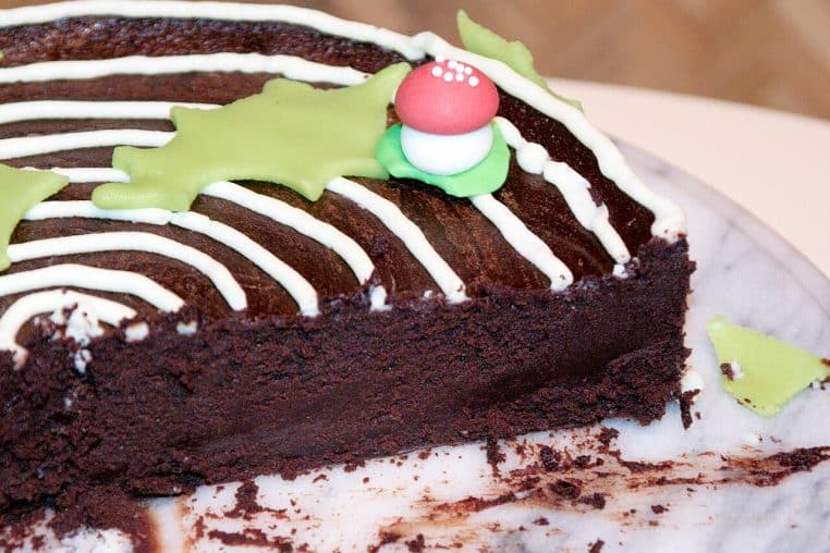 Tranche de cake moelleux au chocolat vue de biais, texture serrée et humide, décor simple, arrière-plan flou, prise de vue horizontale.