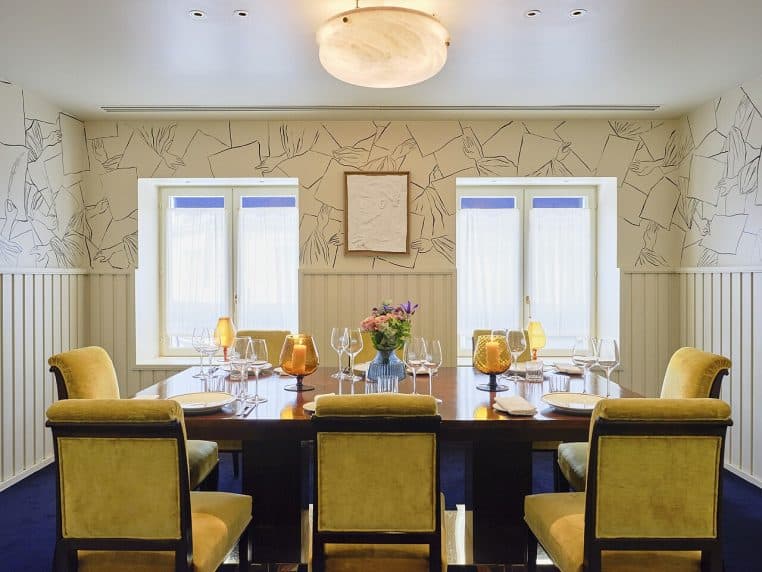 Salon de Drouant en vue horizontale avec boiseries, banquettes et lumière douce, ambiance feutrée dans le 2ᵉ arrondissement de Paris.