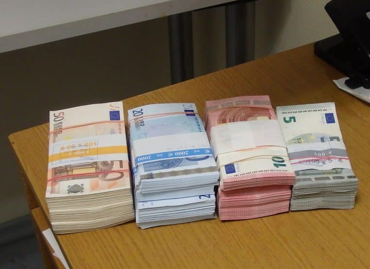 Plusieurs coupures de 5, 10, 20 et 50 euros posées à plat en format horizontal, éclairage doux et neutre.
