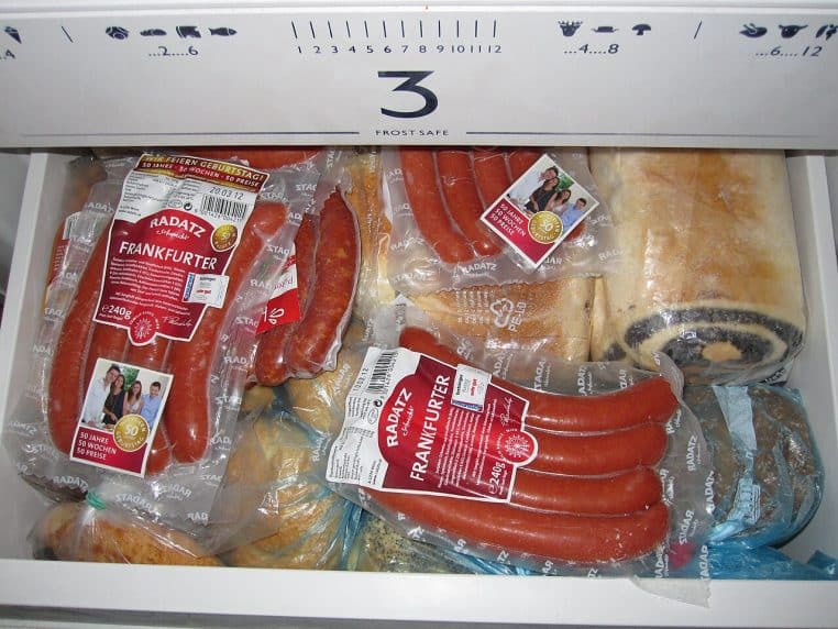 Tiroir de congélateur rempli de produits emballés et portions familiales destinés à la conservation longue.