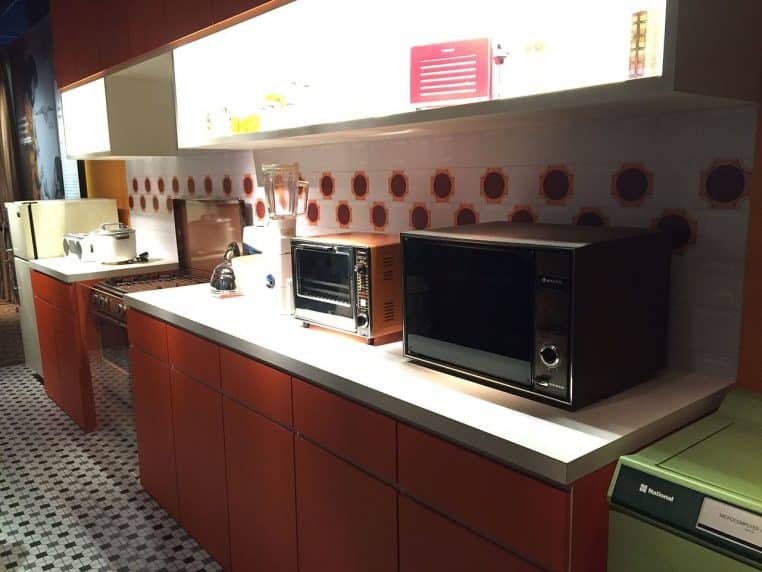 Cuisine typique des années 70-80 à Singapour avec rangements ouverts, électroménager et plan de travail lumineux.