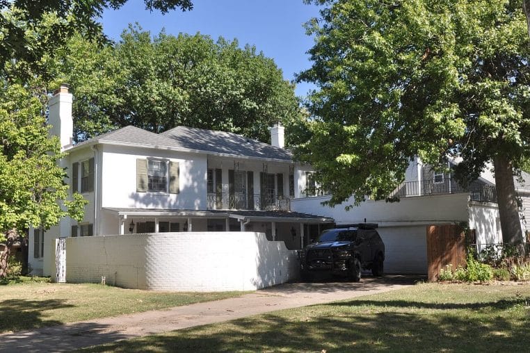 Maison avec allée carrossable et garage à l’arrière, prise en plan large, pertinente pour illustrer la lecture des accès et dépendances.
