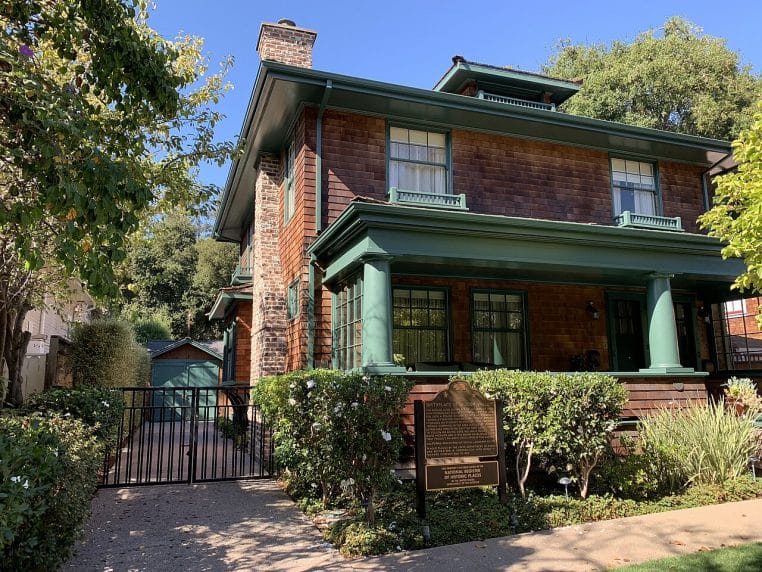 Façade de maison américaine avec garage accolé, allée et végétation, montrant un volume bâti facilement identifiable depuis le ciel.